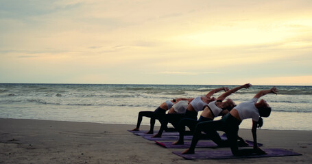 Professional group females yoga practice in class on mat stretching