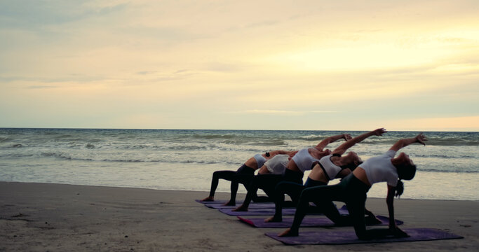 Professional group females yoga practice in class on mat stretching