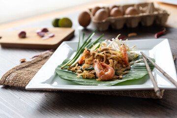 Pad Thai with fresh shrimp on a wooden table Pad Thai is a delicious Thai street food. And popular people around the world