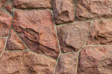 The surface of the masonry is made of roughly hewn large red stones, fitted together.