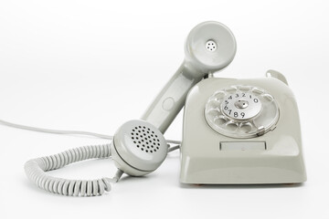 Detail photo of a gray vintage rotary telephone in a bright studio setting.