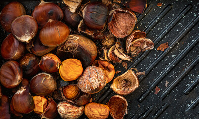 Roasted chestnuts on a black concrete Background. Chestnuts for Christmas close-up. Food Wallpaper.