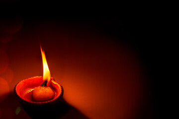 Happy Diwali - One Diya oil clay lamp illuminated as a religious tradition during Diwali...