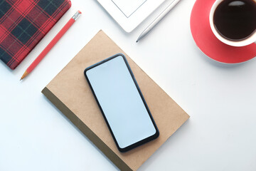 top view of smart phone and notepad on table 