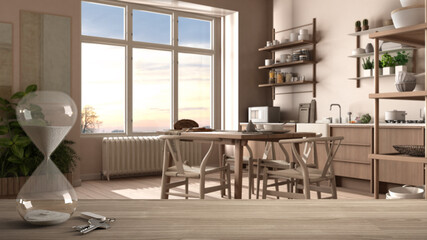 Wooden table, desk or shelf with crystal modern hourglass measuring passing time in a countdown to a deadline over rustic kitchen, dining table, interior design, copy space background