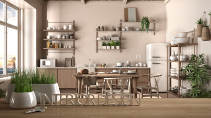 Wooden table, desk or shelf with potted grass plant, house keys and 3D letters making the words interior design, over rustic kitchen with table, project concept copy space background