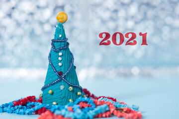 Christmas or new year card. Toy Christmas tree on a bokeh background. The inscription 2021.