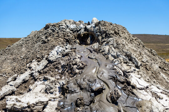 Close up view on upper side of mud volcano. There is slow eruption of mud flow (cold mix of oil, dirt & other liquids). Shot near Kerch, Crimea