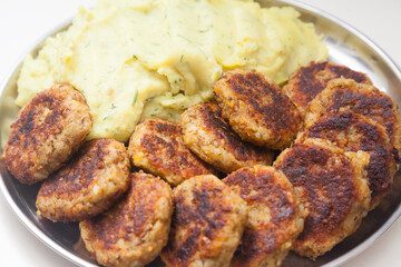 Closeup of plate with mashed potatoes and cutlets