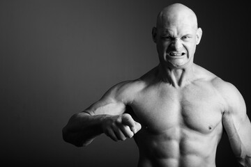 Naklejka premium Bald muscular man shirtless against gray background