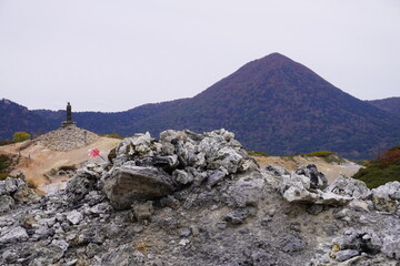 風車（かざぐるま）が岩場に刺さっている恐山の風景
