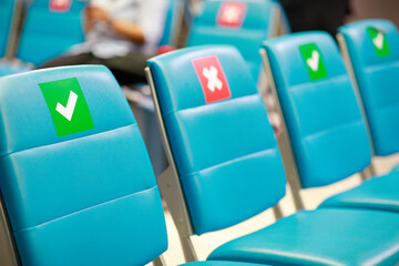  Blue chair alignment in a waiting room with symbol on seat for the social distancing during the Covid-19