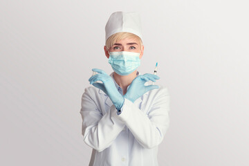 Middle aged woman doctor in protective mask holds syringe