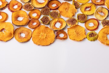 slices of dried persimmon, peach, plum and figs on a white background. dried fruits. eco.