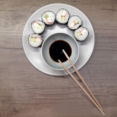 Homemade maki sushi (rolls) with crab sticks, soy sauce and sticks. Japanese food