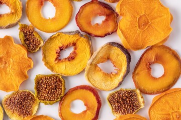 slices of dried persimmon, peach, plum and figs on a white background. dried fruits. eco.