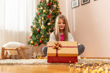 Little girl opening Christmas gifts