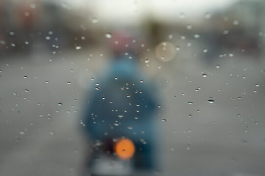 Abstract and blurred of drop water on the grass on front with blur of Blurred image of a motorcyclist on the road.