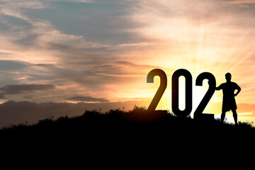 Happy new year 2021 silhouette concept  Human standing with number with beautiful orange sky for change to new year 2021.
