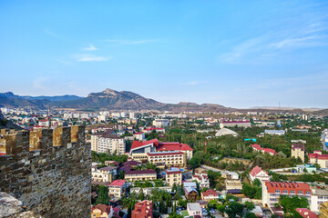Panorama of resort town Sudak (Crimea) as it looks from top of Genoese fortress (part of it on left) - obrazy, fototapety, plakaty
