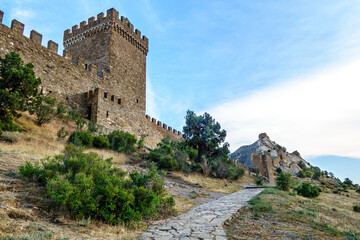 Fototapeta na wymiar Fortification line of medieval Genoese fortress, Sudak, Crimea. Built on almost unattackable rock (more 500 ft height). Tower on foreground named Consul, others named after St. George & St. Elijah