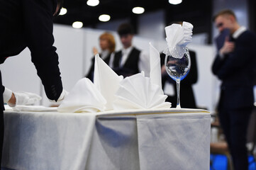 a glass with a napkin is on the table covered with a tablecloth