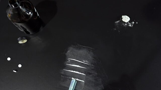 Drug. Cocaine, Money, alcohol, on the table Sniffs Line of cocaine through a rolled 20 euro bill on black table close-up. Addict use Drugs. Addiction, social issues. Destruction of life.