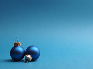 Blue vintage Christmas baubles on a blue background with space for your text or image, seasonal holiday card