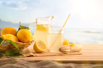Breakfast with Jug and glass with lemonade on the beach - obrazy, fototapety, plakaty