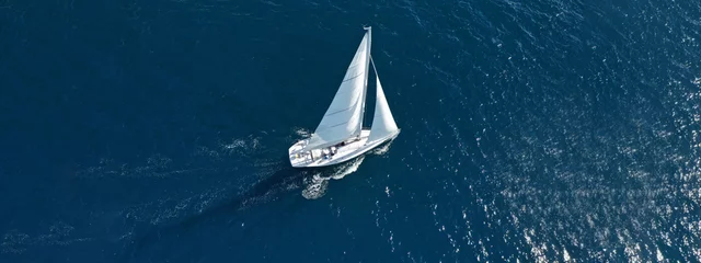 Zelfklevend Fotobehang Aerial drone ultra wide photo of beautiful sailboat cruising deep blue open ocean Mediterranean sea © aerial-drone