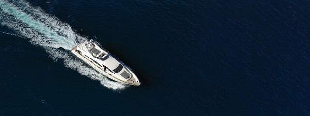 Aerial drone ultra wide photo of luxury yacht with wooden deck cruising in Aegean deep blue sea