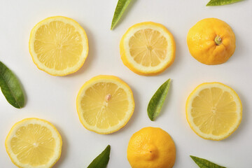 Several lemon slices and leaves on white table top