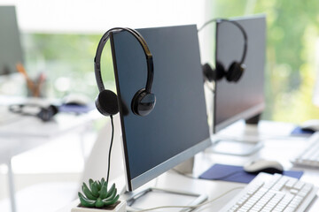 Computer monitor with empty space for your design and VOIP headset on desk at modern office