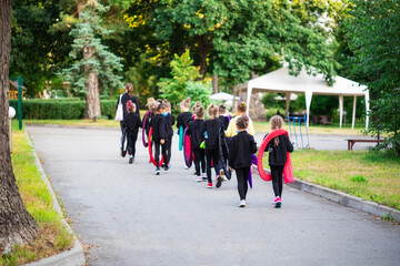 Group of girls gymnasts with hoops and the coach walking on the road