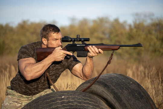 Close up image of male shooting rifle. Image taken during big game hunting trip. Hunting period, autumn season open.
