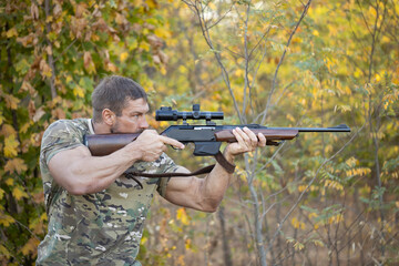 Close up image of male shooting rifle. Image taken during big game hunting trip. Hunting period, autumn season open.