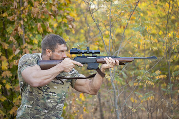 Close up image of male shooting rifle. Image taken during big game hunting trip. Hunting period,...