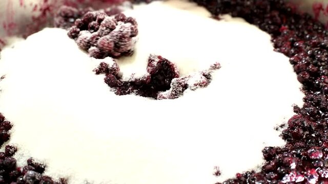 Falling asleep and stirring sugar in blueberry jam, close-up, background