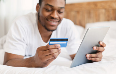 African American Man Shopping Online Using Digital Tablet At Home