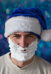 Frowning Santa Claus in a blue cap with a white beard. bokeh background for New year and Christmas