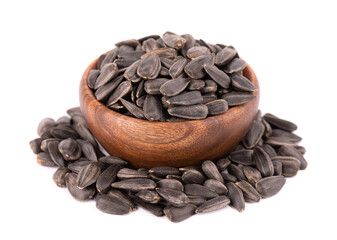 Sunflower seeds isolated on white background. Pile of fried sunflower seeds in wooden bowl.