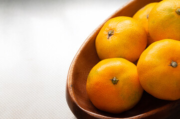 木製のボウルに盛られた新鮮な日本のミカン マンダリンオレンジ タンジェリン クロースアップ 日本