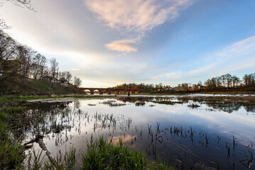 Late evening sunset view of old historic brick bridge over river Venta.