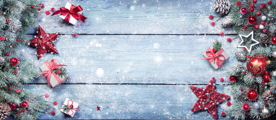Fir Branches With Red Ornament And Rustic Giftbox On Snowy Plank - Christmas Background