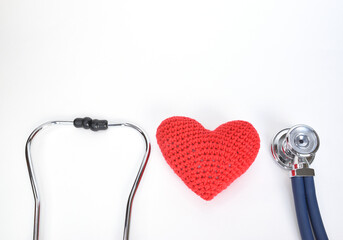 Stethoscope sound head, headband and red knitted heart on white background
