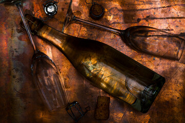 Champagne bottle and glass flutes on copper surface