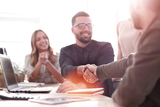 background image of the handshake of business partners in the office