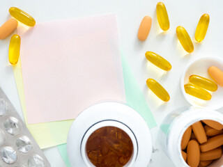 Empty stickers for your text and scattered tablets on a white table, top view, flatly, copyspace, close-up. The concept of reminders, to leave a note. Medical layout. Pharmacology and medicines