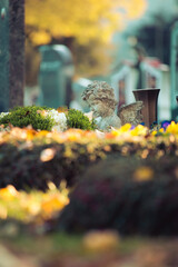 Remembrance concept: White angel on a grave, flowers