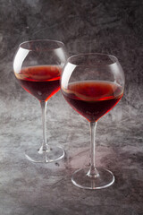 two glasses with red wine on a gray background.
